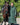 EQUIDRY women's long waterproof horse riding coat in black forest green/cream modelled by rider walking with horse