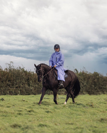 EQUIDRY women's long waterproof horse riding coat in blue lilac/grey rider hacking with horse